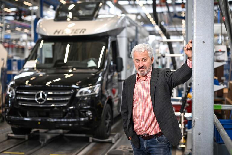 JANUSZ EICHENDORFF, Vorsitzender des Konzernbetriebsrats in Werkshalle mit Fahrzeug
